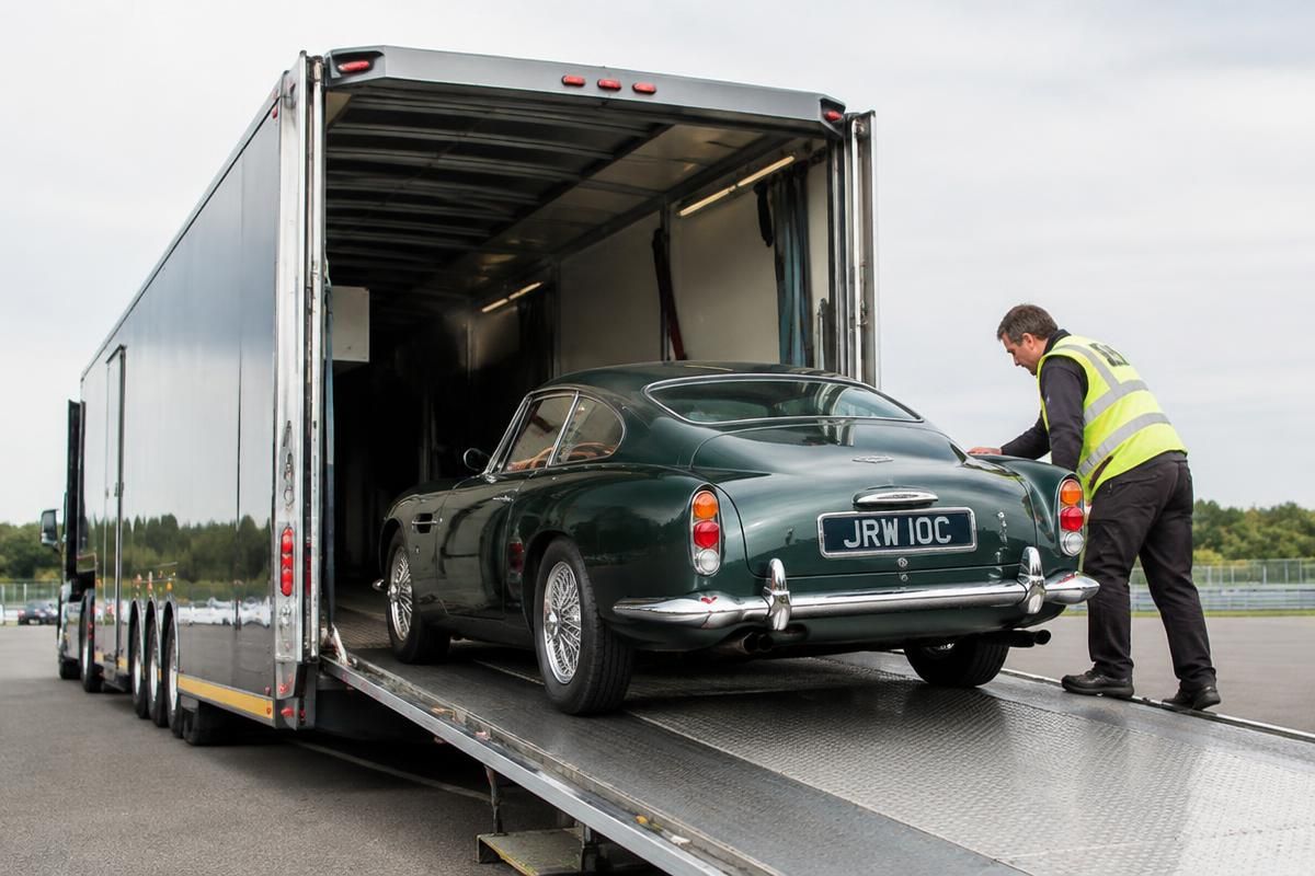 Classic car being loaded into an enclosed auto transport trailer